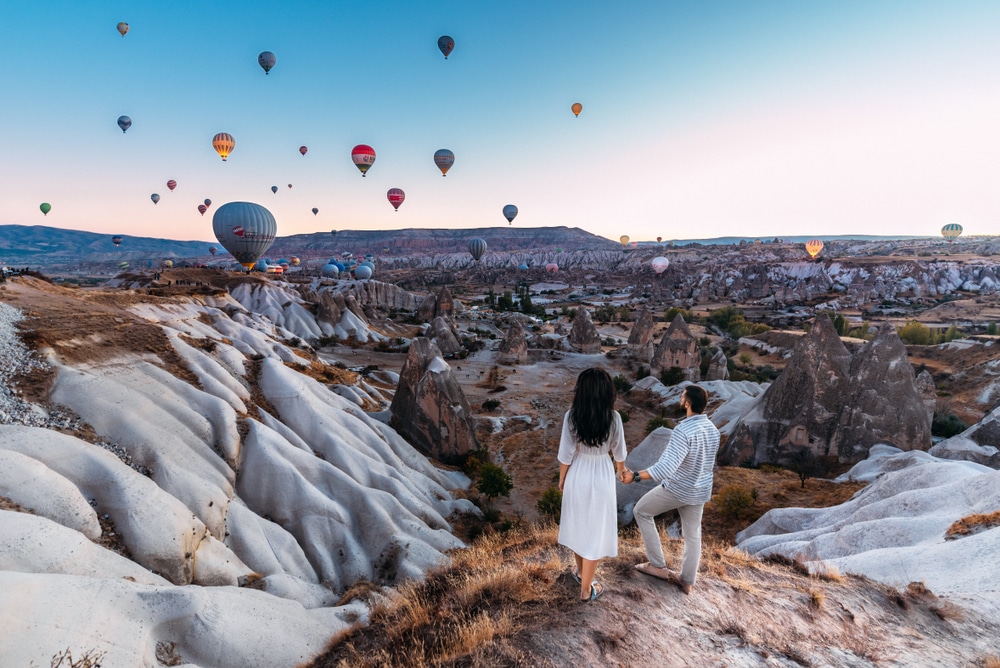 In addition to romantic restaurants in Albuquerque, there are plenty of fun things to do in Albuquerque for couples - like this couple overlooking hot air balloons over the new mexico landscape