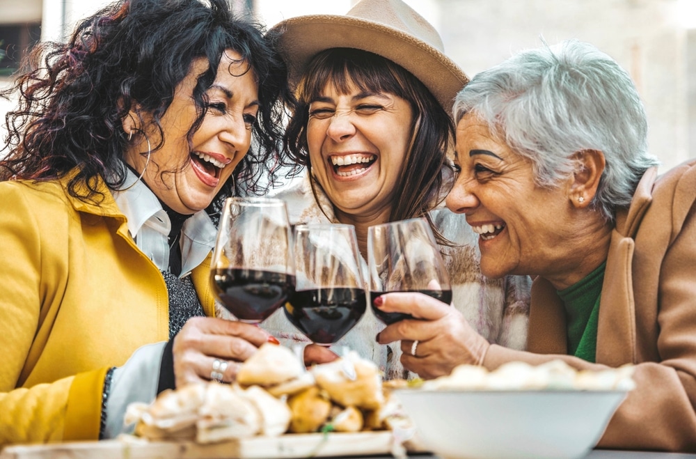 Three senior women cheers their wine glasses as one of Old Town Albuquerque Restaurants.