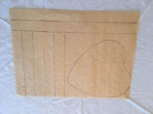A tan sheet of paper features hand-drawn vertical lines on the left and a large heart outline on the right.